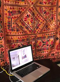 Makeshift office with tapestry and laptop computer