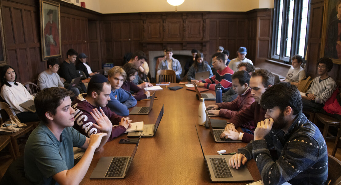 students with computers at a large table