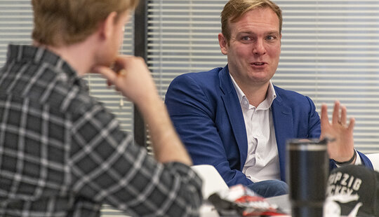 Two people talking at a table.