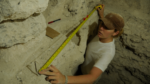 Sarah Newman taking measurements in a pyramid at El Zotz.